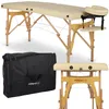 A beige massage table with wooden legs and a black carrying case. Produktbild-Vorschau