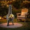 A garden patio at dusk with a fire pit and a chair. Anteprima dell’immagine prodotto