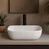 A bathroom sink with a faucet and plants in the background. Náhľad obrázku produktu