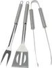 A set of stainless steel barbecue tools including a spatula, fork, and tongs, arranged on a white background. Anteprima dell’immagine prodotto