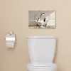 A bathroom scene with a toilet and a piece of wall art. Produktbild-Vorschau