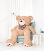 A large teddy bear sits in a chair in a room with white curtains. Náhľad obrázku produktu