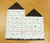 Two fabric advent calendars with numbered pockets are laid out on a wooden floor. Podgląd zdjęcia produktu