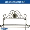 A close-up of a black metal wine rack with decorative scrollwork and a flower motif. Produktbild-Vorschau