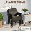 Stacked brown rattan garden chairs on a patio next to a plant and a table with a tablecloth. Produktbild-Vorschau