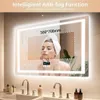 A woman with a towel on her head is looking into a lighted mirror in a bathroom. Náhľad obrázku produktu