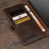 A close-up view of a brown leather wallet with cards and cash inserted, resting on a textured surface. Anteprima dell’immagine prodotto