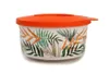 A round food container with a tropical leaf pattern and an orange lid, isolated on a white background. Produktbild-Vorschau