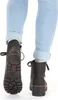 A close-up view of a person's legs wearing blue jeans and black ankle boots. Produktbild-Vorschau