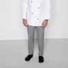 A person wearing a chef's uniform and checkered pants, standing against a plain background. Produktbild-Vorschau
