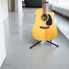 An acoustic guitar on a stand in a modern hallway. Náhľad obrázku produktu