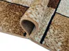 A close-up view of a rolled-up rug with a geometric pattern. Náhled obrázku produktu