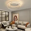 A modern living room with a sofa, armchair, coffee table, and a large abstract painting on the wall. A contemporary ceiling light is prominently displayed. Produktbild-Vorschau