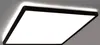 A close-up, angled view of a modern, square LED ceiling light with a black frame and a bright white light panel. The light is mounted on a ceiling, with a subtle glow emanating from behind the fixture. Produktbild-Vorschau