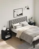 A modern bedroom with a tufted headboard bed, two black nightstands, and a piece of abstract art on the wall. Náhled obrázku produktu