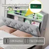 A close-up view of a bed's headboard, highlighting integrated charging features and storage shelves. Náhled obrázku produktu