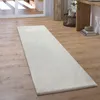 A white shaggy rug runner on a wooden floor in a hallway, with baskets and a wooden console table in the background. Anteprima dell’immagine prodotto