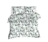 A duvet cover and two pillowcases with a green leaf pattern, laid out on a white surface. Produktbild-Vorschau