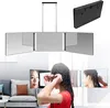 A woman is doing her hair in front of a tri-fold mirror with LED lights. Produktbild-Vorschau