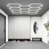 A modern hallway with a hexagonal LED ceiling light, a large white wardrobe with shoe storage, and a bench with a mirror. Voir les images du produit