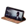A smartphone in a brown flip case is displayed on a white background, showing a movie poster on its screen. Produktbild-Vorschau