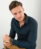 A man wearing a blue shirt and a watch is posing for a product shot. Náhled obrázku produktu