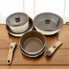 A set of cookware with two removable handles, displayed on a wooden surface. Produktbild-Vorschau