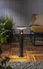 A solar-powered garden light is shown on a wooden deck at dusk, with a chair and plants in the background. Podgląd zdjęcia produktu