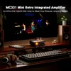 A desk setup with a computer monitor displaying a concert, an amplifier, speakers, headphones, and a keyboard. Produktbild-Vorschau