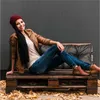 A woman is sitting on a pallet bench outdoors in autumn. Náhled obrázku produktu