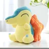 A plush toy of a Pokemon character sitting on a white surface with a blurred background. Produktbild-Vorschau