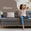 A woman is relaxing on a sofa with her hands behind her head, looking up and to the side with a smile. The image has a text overlay with German text. Produktbild-Vorschau