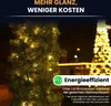 A close-up of a decorated artificial Christmas garland with lights, with a blurred Christmas tree in the background. Produktbild-Vorschau
