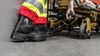 A person wearing safety boots and high-visibility clothing is pushing a stretcher. Produktbild-Vorschau