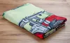 A folded towel with a cartoon tractor print on a wooden surface. Produktbild-Vorschau