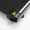 A close-up view of the side of a black treadmill, showing a warning label. Anteprima dell’immagine prodotto