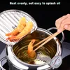 A person is using chopsticks to remove a fried shrimp from a deep fryer pot with a thermometer attached. Podgląd zdjęcia produktu