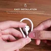 Hands holding white ear hooks for AirPods, demonstrating installation. Produktbild-Vorschau