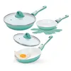 A set of teal and white ceramic frying pans with glass lids and a trivet, displayed on a white background. One pan contains a fried egg. Produktbild-Vorschau