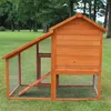 A wooden chicken coop with an attached run sits on a grassy lawn. Produktbild-Vorschau