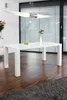 A white dining table with a vase and apples on it, in a modern dining room setting. Produktbild-Vorschau