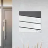 A mailbox with a newspaper compartment mounted on a textured wall next to a door. Náhled obrázku produktu