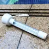 A thermometer resting on wet stone next to a pool. Produktbild-Vorschau