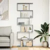 A modern living room with a gray bookshelf filled with books and decor, next to a sofa and a large potted plant. Náhľad obrázku produktu