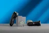 Two black electric shavers and replacement heads are displayed on a gray surface against a blue background with diagonal lighting. Voir les images du produit