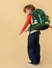 A young boy wearing a backpack and jeans, posing against a plain background. Produktbild-Vorschau