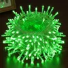 A coiled string of green LED lights on a wooden surface. Produktbild-Vorschau