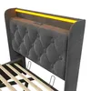 A close-up view of a gray upholstered bed frame with a tufted headboard and integrated LED lighting. Produktbild-Vorschau