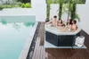 A group of people relaxing in a hot tub next to a swimming pool. Produktbild-Vorschau