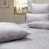 A bedroom scene with a bed covered in white bedding and pillows. Produktbild-Vorschau